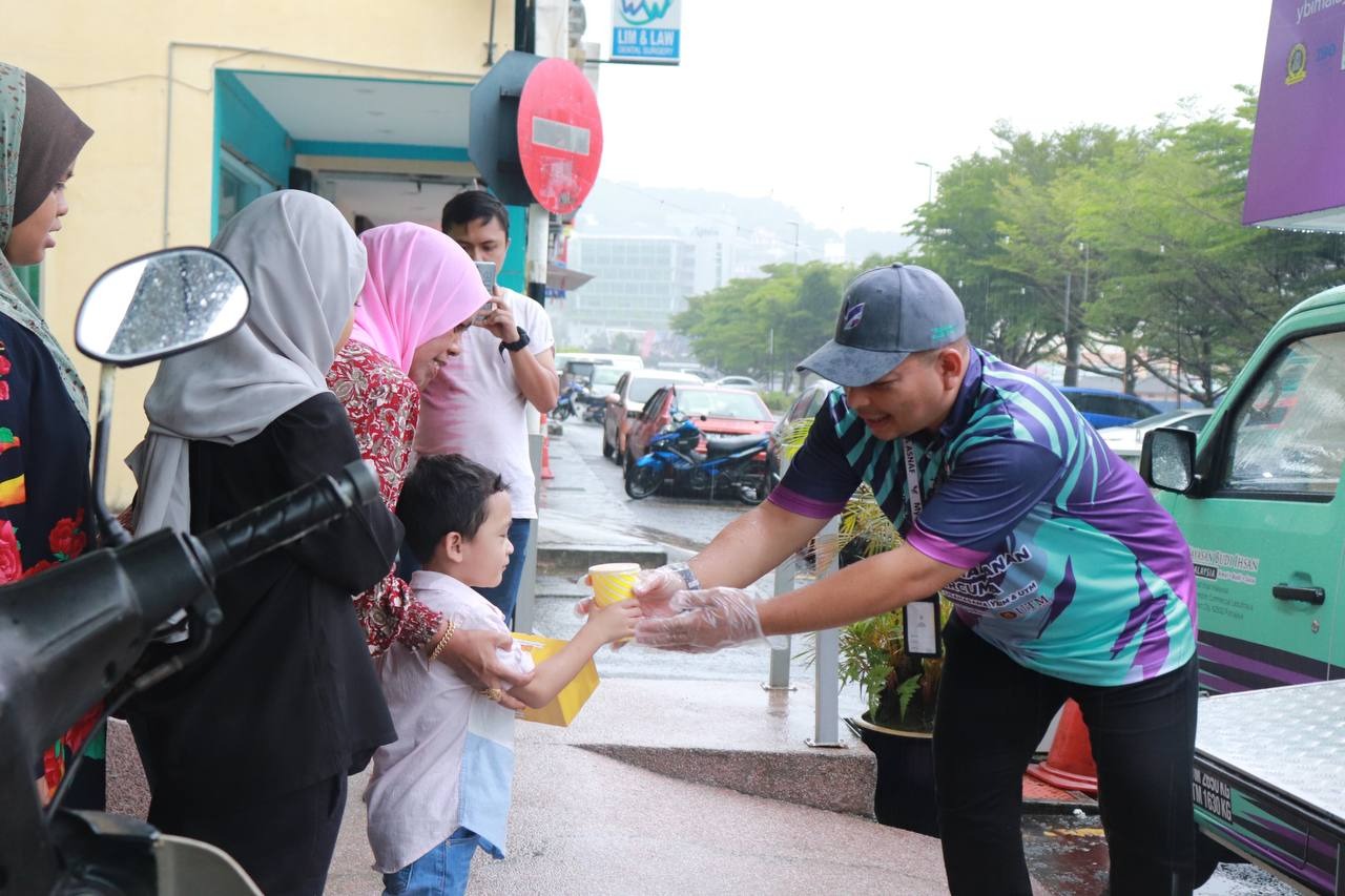 Petugas FMOW sedang mengagihkan pek makanan kepada anak-anak yatim